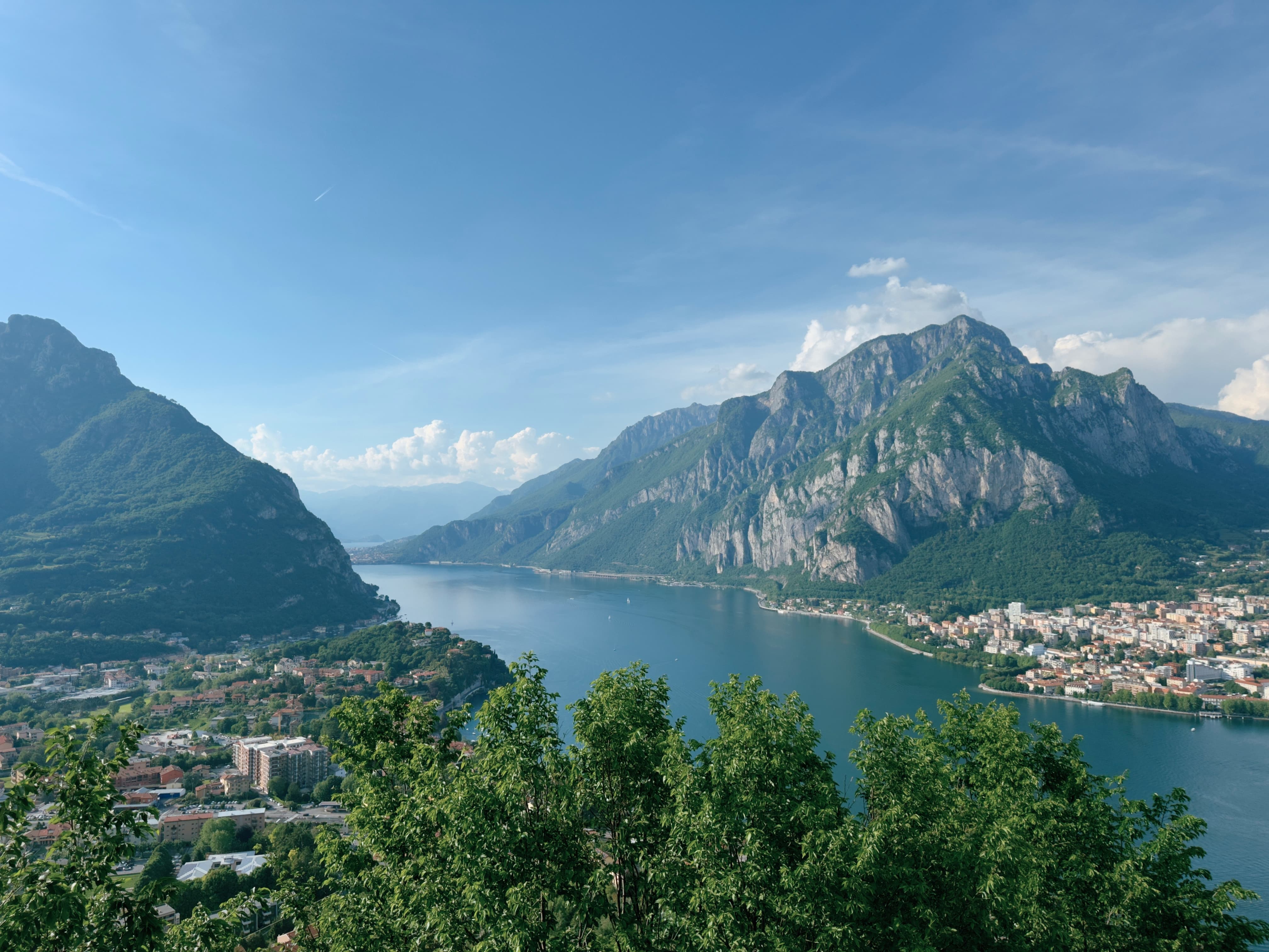 Panoramic view of Lake Como from above, with Monte Coltignone on the right and Lecco spreading along the lakeshore.