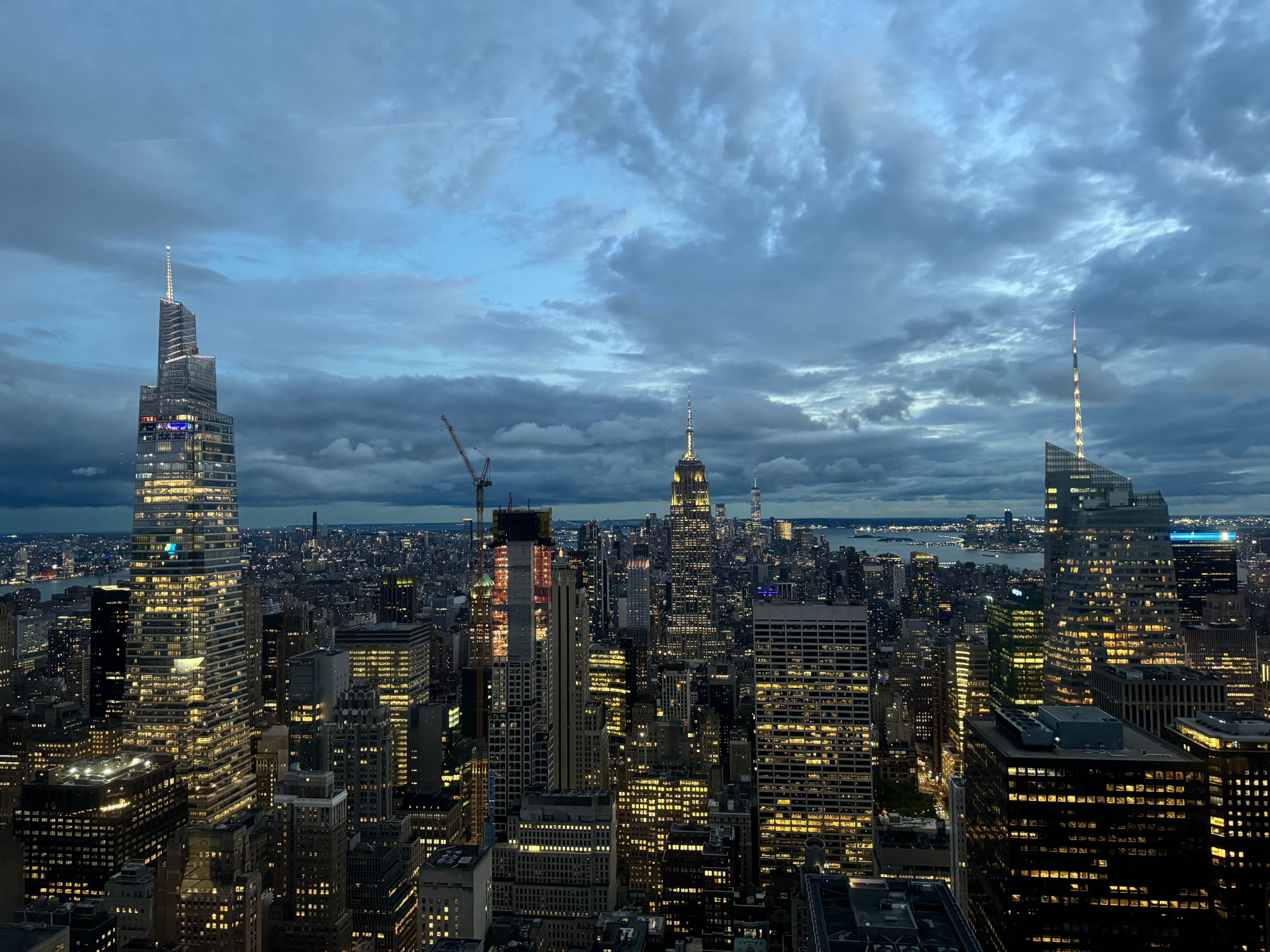 Picture of the New York City skyline at dusk. The building lights are already on, but the sky isn't dark yet.