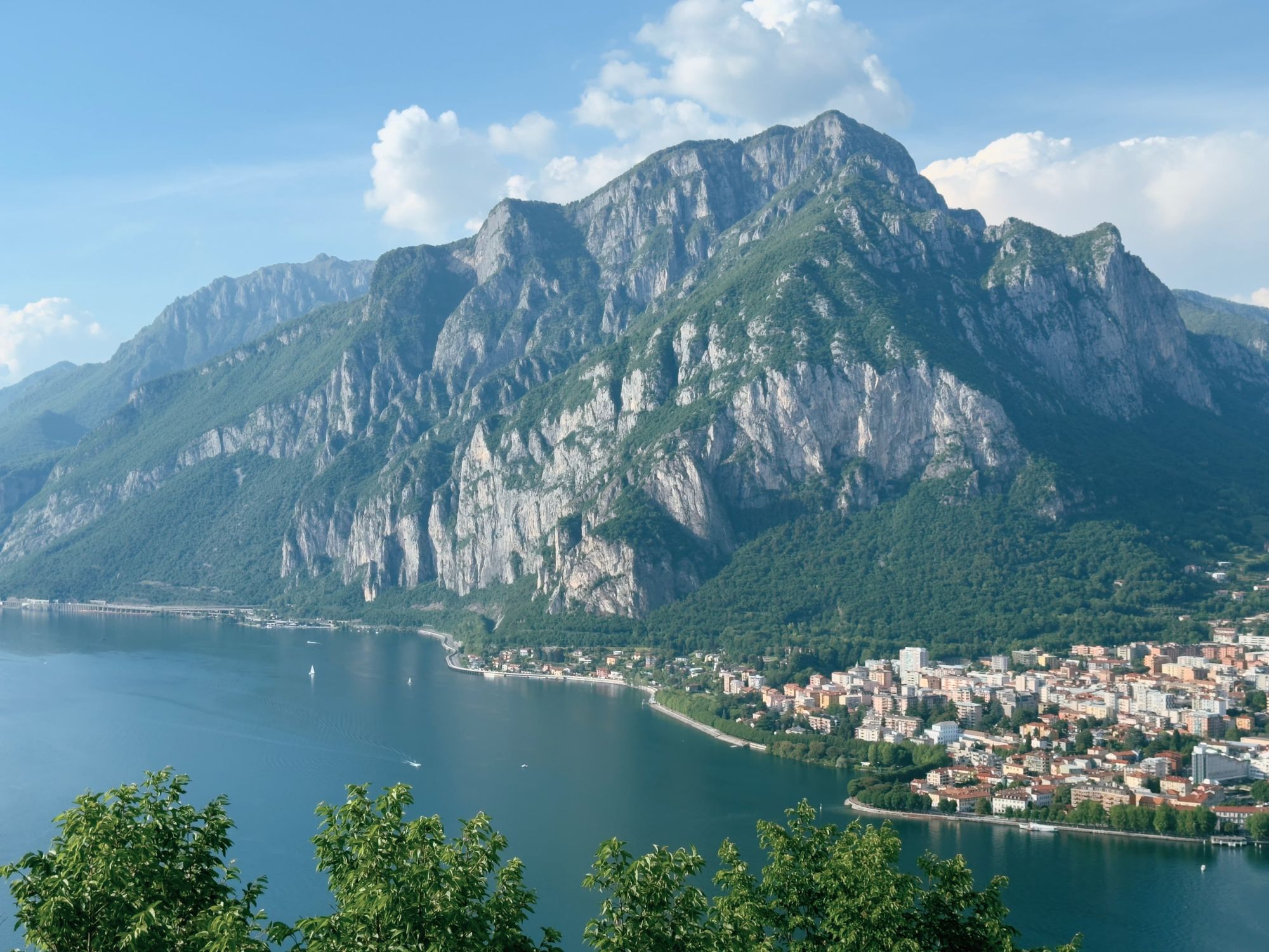 View of Monte Coltignone rising above the eastern shore of Lake Como, with the city of Lecco visible below along the waterfront.