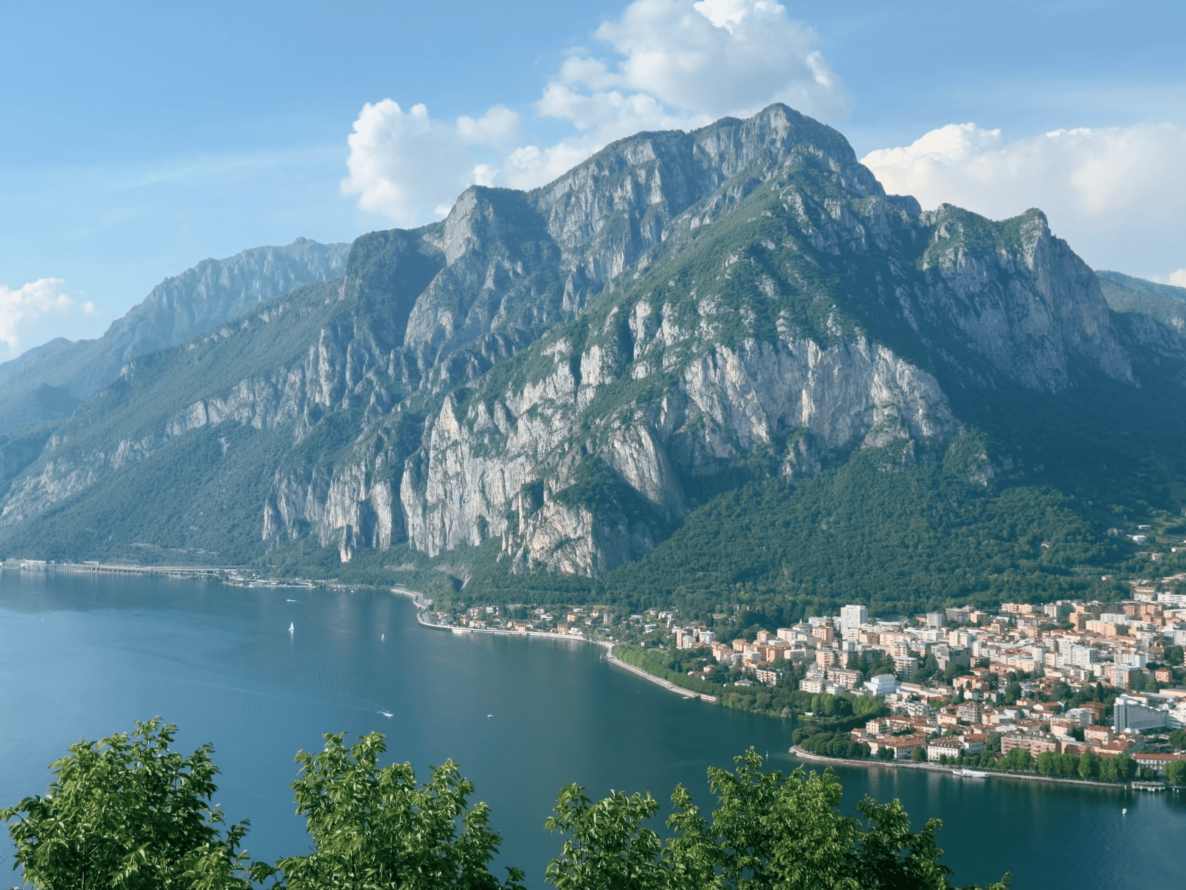 View of Monte Coltignone rising above the eastern shore of Lake Como, with the city of Lecco visible below along the waterfront.