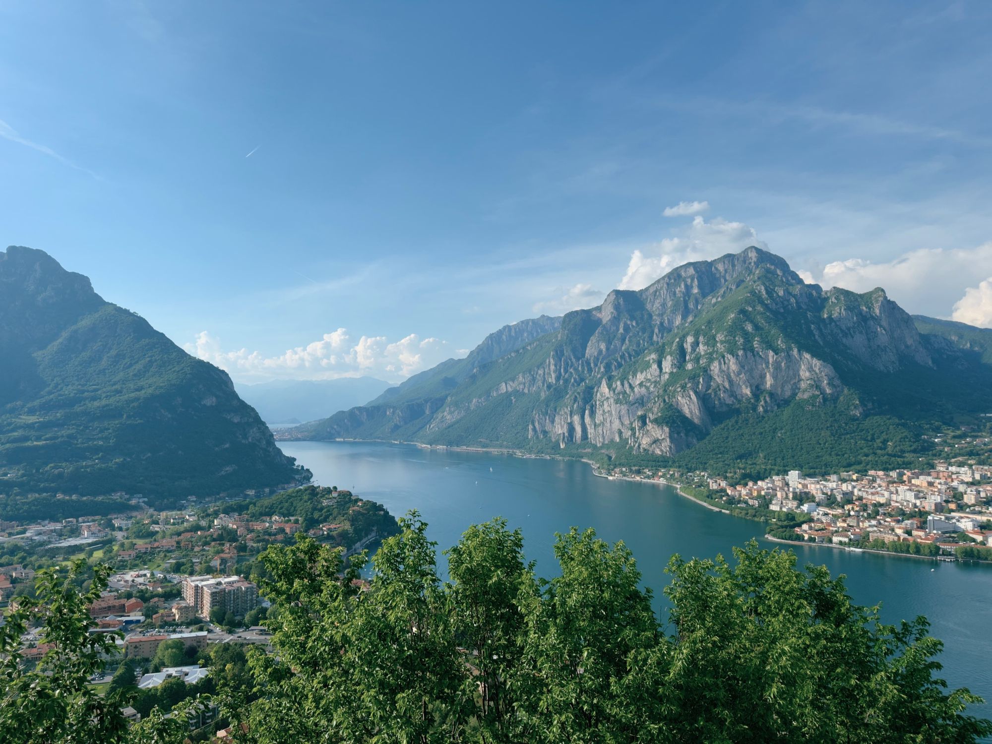 Panoramic view of Lake Como from above, with Monte Coltignone on the right and Lecco spreading along the lakeshore.